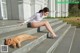 A woman sitting on the steps of a building next to a cat.