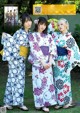 A group of three women in kimonos posing for a picture.