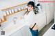 A woman standing in a kitchen next to a sink.