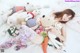 A woman laying on a bed surrounded by stuffed animals.