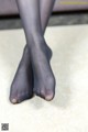 A close up of a woman's legs in black stockings.