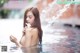 A woman in a swimming pool holding a flower.