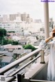 A woman standing on a balcony looking out over a city.