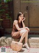 A woman sitting on the steps of a building with a handbag.