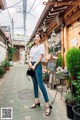 A woman standing in front of a flower shop.