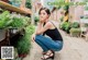 A woman sitting on the ground in front of a flower shop.