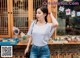 A woman standing in front of a flower shop.