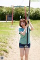 A young woman is swinging on a swing set.