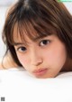 A young woman laying on top of a bed.