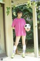 A young woman holding a soccer ball on a porch.