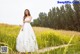 A woman in a white dress standing in a field of flowers.