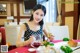 A woman sitting at a table with a plate of food.